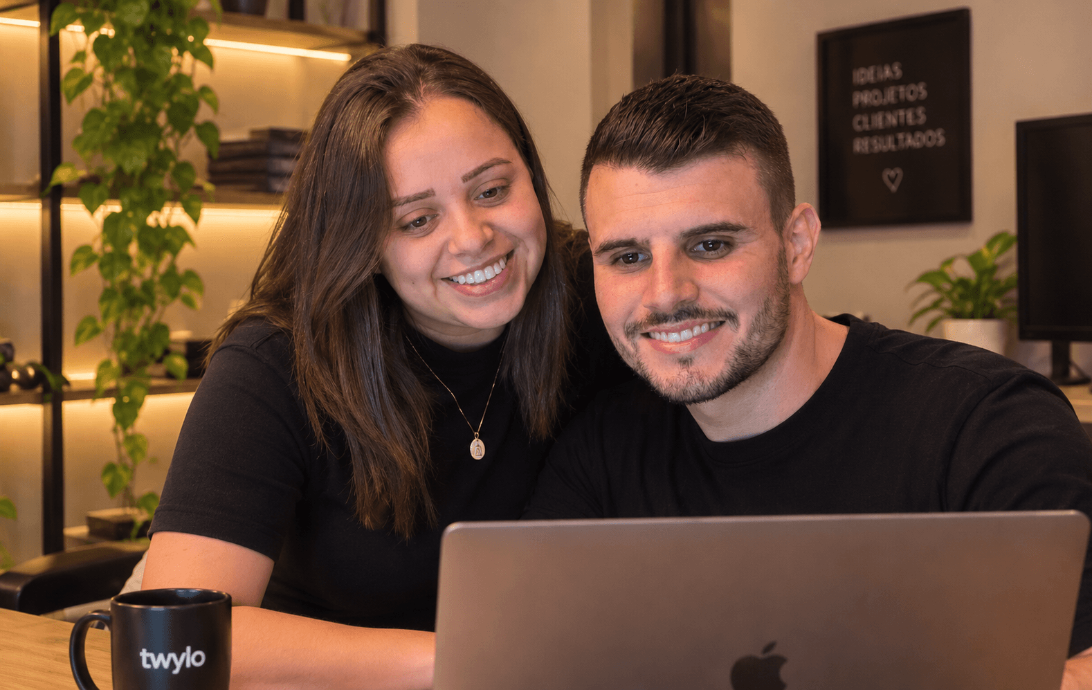 O casal da Twylo trabalhando junto em um notebook