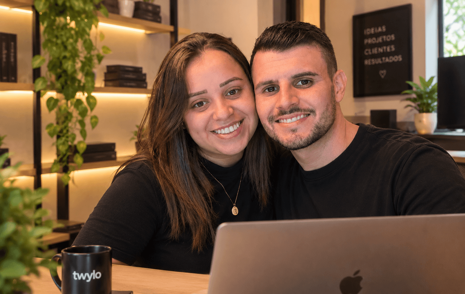 O casal por trás da Twylo sorrindo no escritório